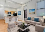 Thumbnail 17 of 23 - A modern living room with a kitchen area in the background.