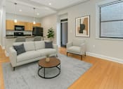 Thumbnail 15 of 23 - A modern living room with a white couch and a coffee table.