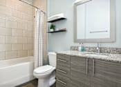 Thumbnail 9 of 33 - A bathroom with a toilet, sink, and shower.