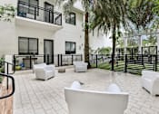 Thumbnail 19 of 33 - A patio with white furniture and a black railing.