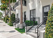 Thumbnail 26 of 33 - A white building with black railings and a palm tree in front.