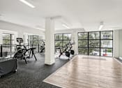 Thumbnail 17 of 33 - A gym with a variety of equipment and a view of the outside.