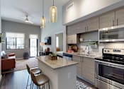 Thumbnail 4 of 33 - A modern kitchen with a large island and a dining area.