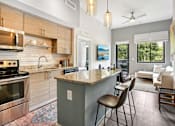 Thumbnail 6 of 33 - A modern kitchen with a large island and a dining area.