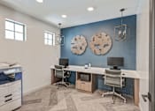 Thumbnail 18 of 18 - A room with a blue wall and a white desk with two monitors.