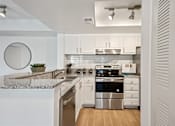 Thumbnail 2 of 18 - A modern kitchen with white cabinets and a marble countertop.