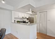 Thumbnail 3 of 18 - A kitchen with white cabinets and a counter.