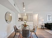 Thumbnail 4 of 18 - A dining room with a glass table and chairs.