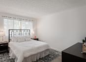 Thumbnail 7 of 18 - A bedroom with a bed, nightstands, and a window.