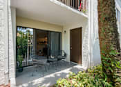 Thumbnail 10 of 18 - A patio with a table and chairs is seen through a doorway.