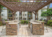 Thumbnail 14 of 18 - A patio with a pergola and two brick pillars.