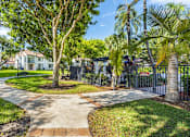 Thumbnail 8 of 29 - A tree in a grassy area with a pathway leading to a building.
