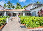 Thumbnail 9 of 29 - A white house with a red roof and a brick pathway leading to the front door.