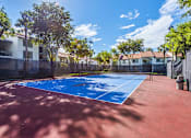 Thumbnail 10 of 29 - A tennis court with a blue surface and red court lines.