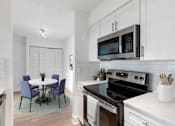 Thumbnail 20 of 29 - A modern kitchen with a table and chairs.