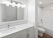 Thumbnail 24 of 29 - A white bathroom with a sink, mirror, toilet and bathtub.