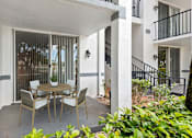 Thumbnail 25 of 29 - A patio with a table and chairs is surrounded by white columns.