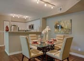 Thumbnail 27 of 29 - A dining room with a glass table and chairs.