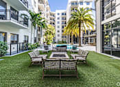 Thumbnail 30 of 33 - A patio with a table and chairs surrounded by buildings.