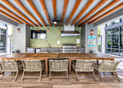 Thumbnail 29 of 33 - A wooden table surrounded by chairs under a striped ceiling.