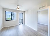 Thumbnail 11 of 33 - A spacious room with a ceiling fan and a view of the city.