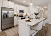 Thumbnail 39 of 47 - A modern kitchen with a large island and stainless steel appliances.