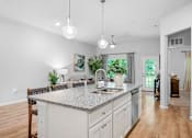 Thumbnail 7 of 33 - A kitchen with a granite countertop and white cabinets.