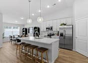 Thumbnail 2 of 26 - A modern kitchen with a white countertop and stainless steel appliances.