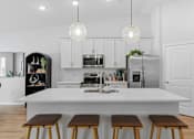 Thumbnail 3 of 26 - A modern kitchen with a white island and stools.