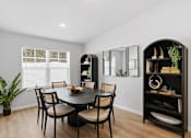 Thumbnail 11 of 26 - A dining room with a round table and chairs.