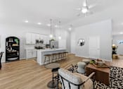 Thumbnail 8 of 26 - A modern kitchen with a bar area and a dining table.