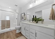 Thumbnail 24 of 26 - A white bathroom with a toilet, sink, and a mirror.