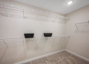 Thumbnail 25 of 26 - Empty shelves in a room with beige carpet.