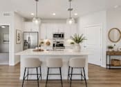 Thumbnail 39 of 47 - A modern kitchen with white cabinets and a central island.