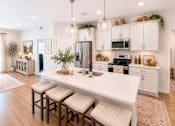 Thumbnail 43 of 47 - A modern kitchen with white cabinets and a central island.