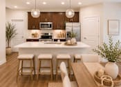 Thumbnail 42 of 47 - A modern kitchen with a wooden table and bar stools.