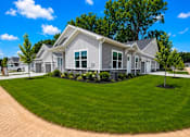 Thumbnail 44 of 47 - A house with a grey roof and white walls is surrounded by a well-manicured lawn.