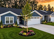 Thumbnail 1 of 47 - A blue house with a white garage door and a tree in the front yard.