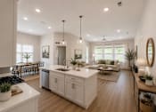 Thumbnail 34 of 38 - A modern kitchen with white cabinets and a central island.