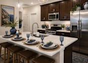 Thumbnail 33 of 47 - A kitchen with a white countertop and brown stools.