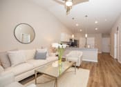 Thumbnail 33 of 33 - A modern living room with a glass coffee table and a white sofa.