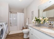 Thumbnail 30 of 33 - A white bathroom with a washer and dryer.