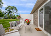 Thumbnail 18 of 33 - A patio with a table, chairs, and flowers.