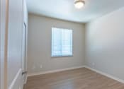 Thumbnail 48 of 51 - A room with a window and wooden flooring.