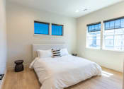 Thumbnail 12 of 82 - A bedroom with a large bed and two windows.
