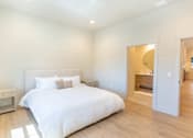 Thumbnail 15 of 82 - A bedroom with a large bed and a nightstand.
