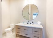 Thumbnail 20 of 82 - A bathroom with a white toilet, sink, and mirror.