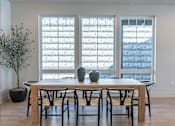 Thumbnail 22 of 82 - A dining room with a table and chairs.