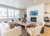 Thumbnail 24 of 82 - A modern living room with a fireplace and a television.