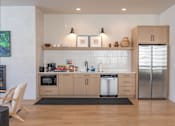 Thumbnail 29 of 82 - A modern kitchen with wooden cabinets and stainless steel appliances.